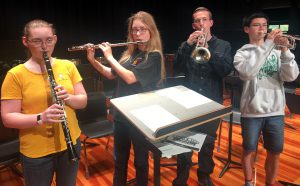 Four students pose for the camera with their instruments. 