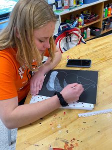 A student works on a drawing in art class