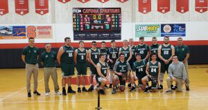 The boys basketball team poses with a tournament trophy