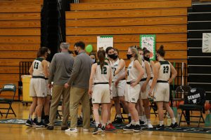 Girls Varsity Basketball team comes together for a huddle