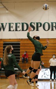 Trinity Davis spikes the ball over the net