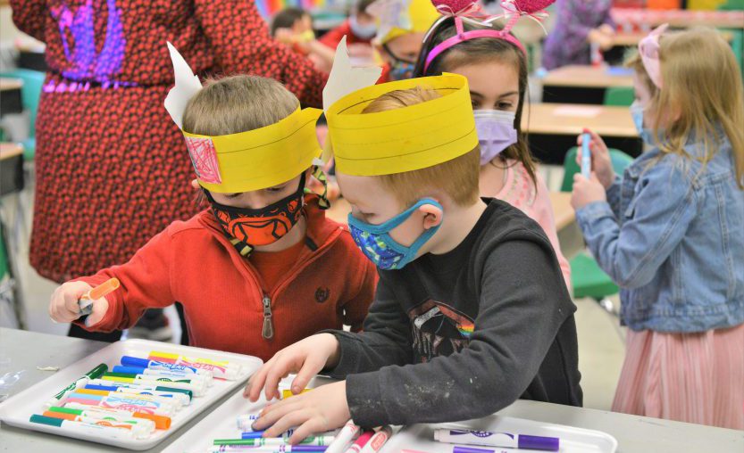 Elementary students choose markers to color with