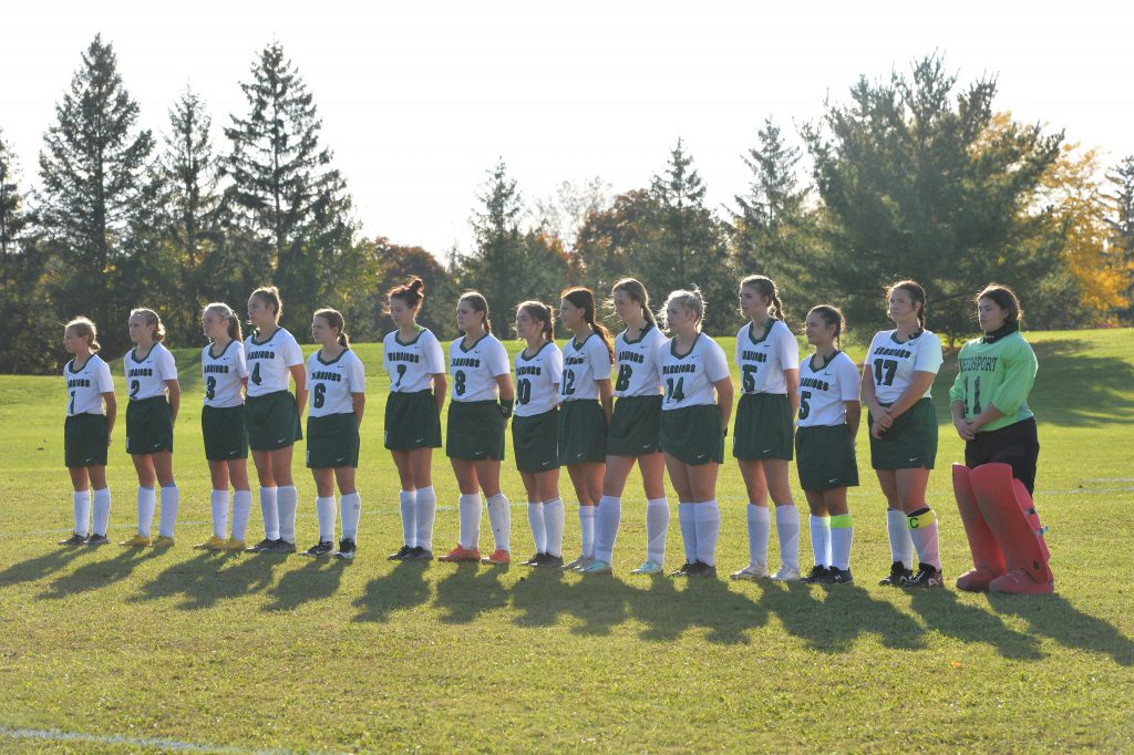 The varsity field hockey team lines up on the field ahead of a game