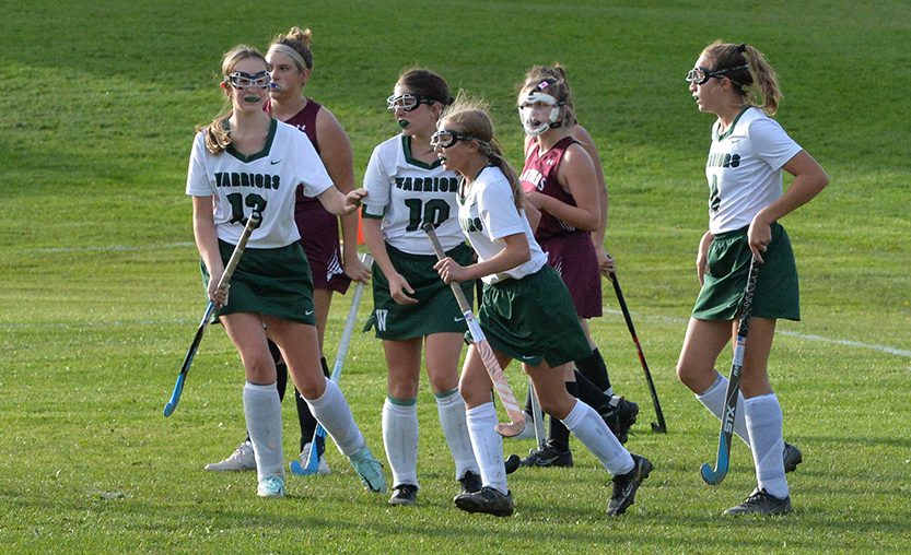 Field Hockey players run down the field during a game