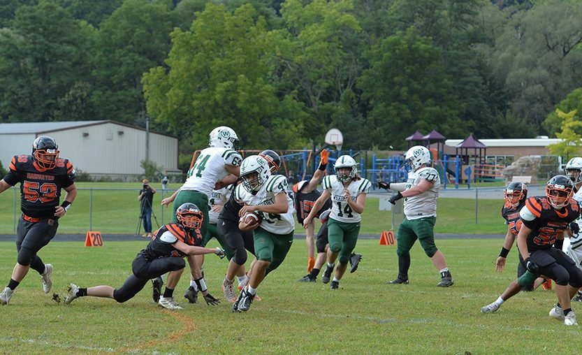 Weedsport varsity football player runs with the ball