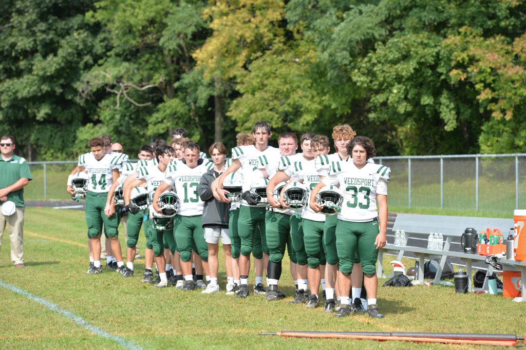 The varsity football team lines the field ahead of a game