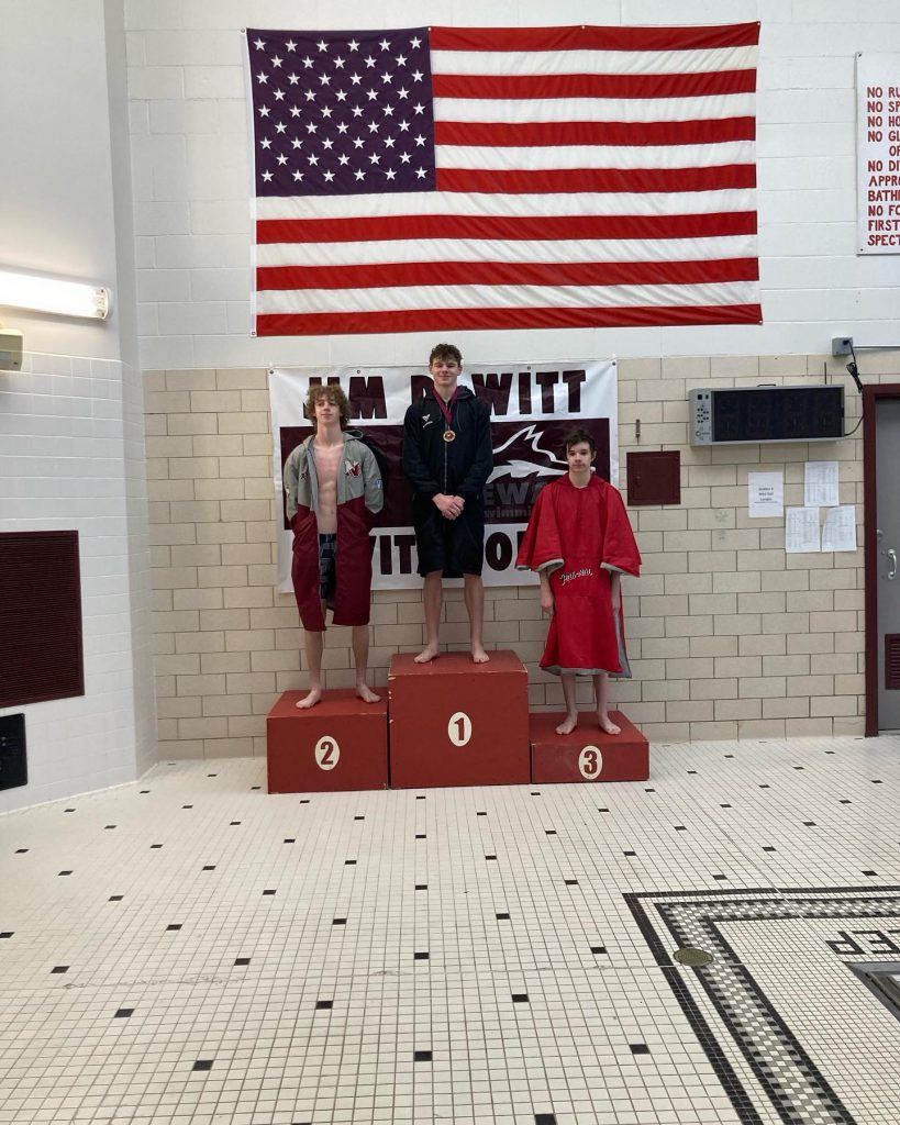 Nolan Carner stands on the podium after coming in first place during the 50 yard freestyle.
