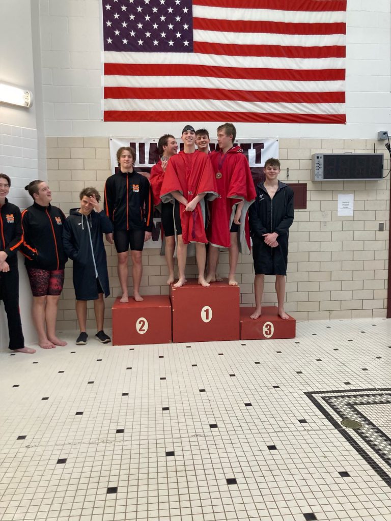 Weedsport students stand on the podium after placing 3rd in the 400 freestyle relay