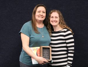 Alicia Grady and Aja Hahn pose with the Library Supporter Award given to Grady.